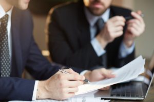 Advogados sentados analisando documentos, representando a assessoria jurídica.