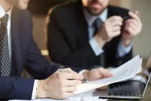 Advogados sentados analisando documentos, representando a assessoria jurídica.