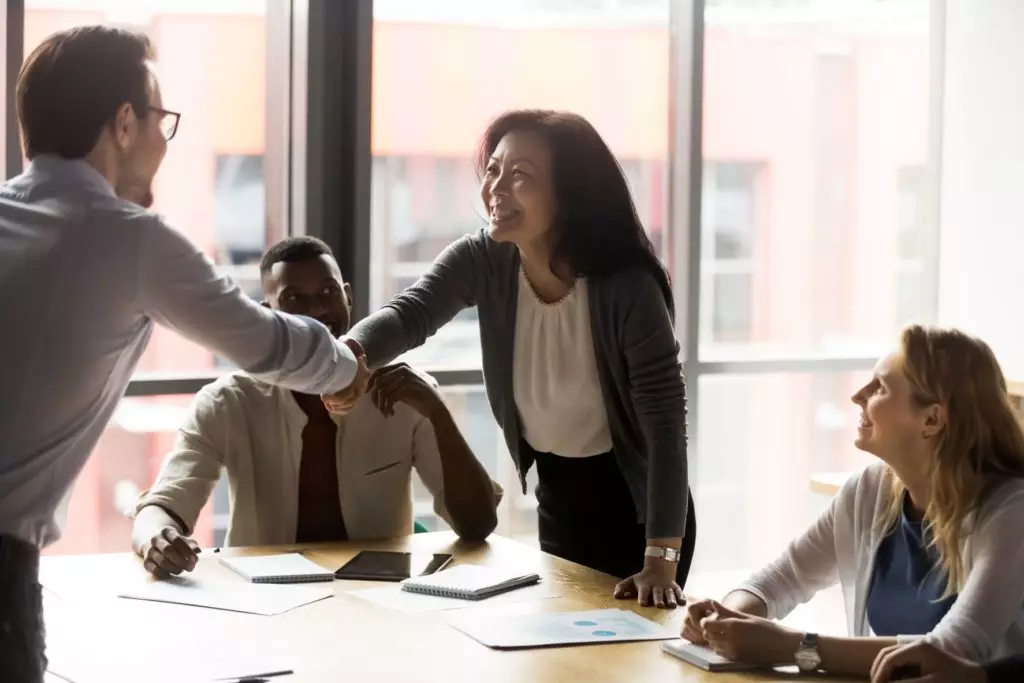 Aperto de mão entre colegas de trabalho em reunião