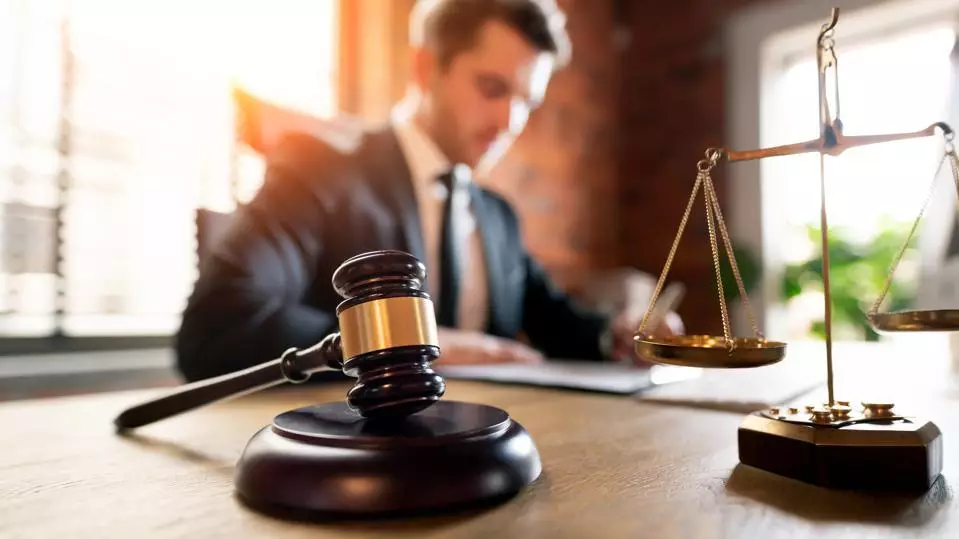 Advogado lendo documentos e martelo da justiça em primeiro plano