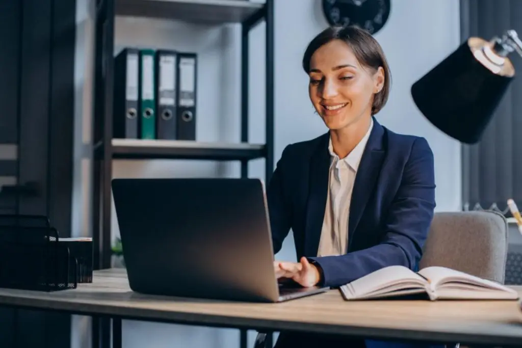 Advogada utilizando notebook em um escritório moderno, representando uma plataforma para advogados.