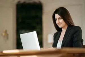 Advogada mexendo no notebook em uma sala ampla, representando o software jurídico com inteligência artificial.