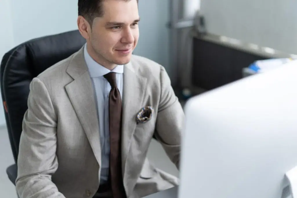 Advogado concentrado mexendo no computador, representando software jurídico para empresas.