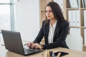 Advogada concentrada em um escritório usando um notebook, representando a advocacia pro bono.